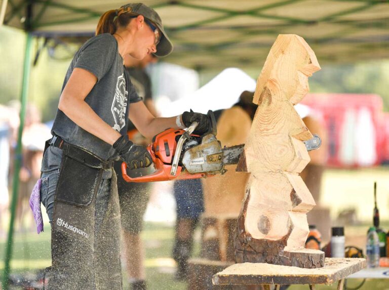 Chainsaw carving artist Heather Bailey creating a wooden sculpture at Tinglewood Festival in Montevallo