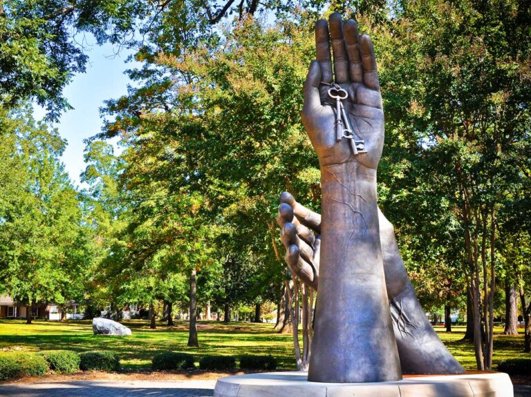Sculpture on the campus of the University of Montevallo featuring two hands that represent teacher and student